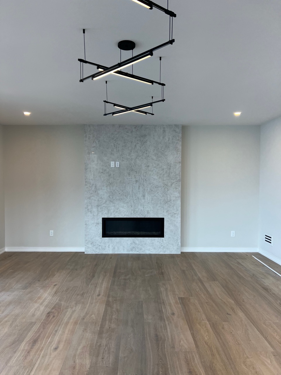 Living room renovation featuring updated flooring and trim